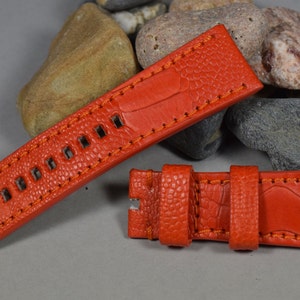 Peut inclure: Un bracelet de montre en cuir orange vif avec une finition texturée et des coutures orange. Le bracelet est doté d'une boucle et est conçu pour une montre avec une largeur de barrette de 22 mm.