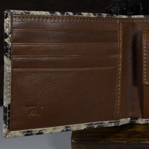 May include: A brown leather wallet with multiple card slots and a billfold. The wallet is made of a snakeskin pattern material.