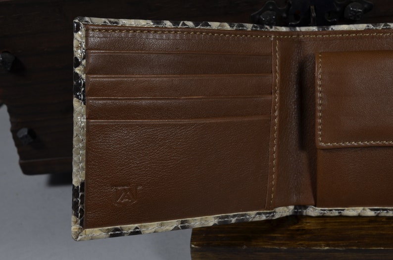 May include: A brown leather wallet with multiple card slots and a billfold. The wallet is made of a snakeskin pattern material.