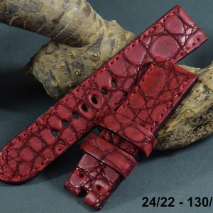 Op de afbeelding: Rood alligator-geëmbost lederen horlogeband met een bandbreedte van 24 mm en een gespbreedte van 22 mm. Het band is 130 mm lang en 80 mm breed.