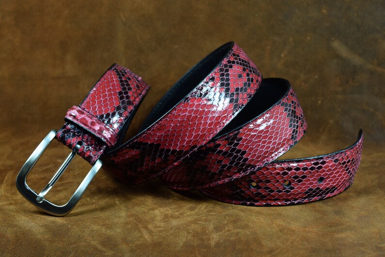 May include: A red and black snakeskin belt with a silver buckle.