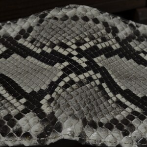 Pode incluir: Close-up de um padr&atilde;o de pele de cobra preto e branco. O padr&atilde;o &eacute; composto por pequenas escamas em forma de diamante.