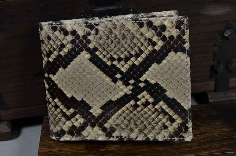 May include: A brown and black snakeskin wallet with a textured pattern.