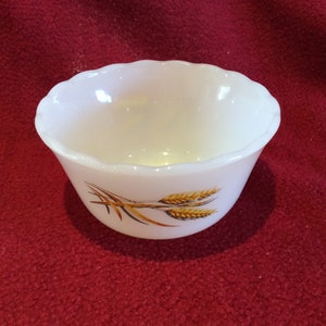 Peut inclure: Un bol en verre laiteux blanc avec un bord festonné et un motif de blé en or et brun.