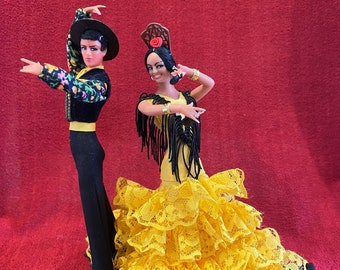 Marin Chiclana Flamenco Male and Female dancing couple. Female is wearing a yellow dress with black trim and playing castanets. 1970's