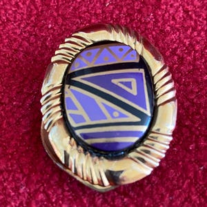 Gold tone metal scarf ring with geometric pattern centre. Costume jewellery. 1970&#39;s