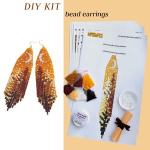 May include: A DIY kit for bead earrings featuring a pair of finished long, tapered earrings with a moon and forest design in orange, cream, and brown beads. The kit includes printed pattern sheets, small bags of colored beads, thread, and hooks.