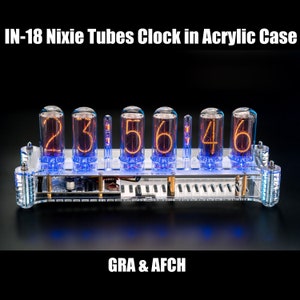 May include: A clear acrylic case encloses a Nixie tube clock displaying the time as 23:56:46. The clock has a silver metal base and is illuminated with blue LEDs.
