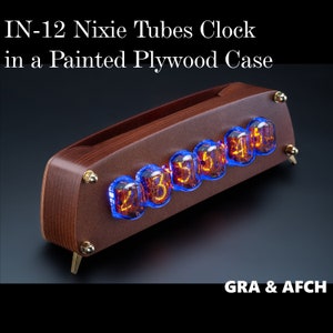 Puede incluir: Un reloj de madera con una caja pintada de marrón y seis tubos Nixie naranjas brillantes que muestran la hora. El reloj está etiquetado como "IN-12 Nixie Tubes Clock in a Painted Plywood Case" y "GRA & AFCH".