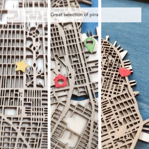 May include: A wooden map with a blue water feature and a variety of colored pins. The pins include a red house, a yellow star, a red heart, and a green location pin. The text "Great selection of pins" is visible at the top of the image.