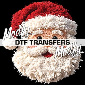 May include: A close-up of a Santa Claus face design with a red hat and white beard. The text "Modify DTF TRANSFERS Modify" is displayed across the image. The design is set against a black background.