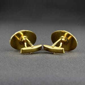 This is a back view of a pair of vintage cufflinks that have a bullet toggle style closure.