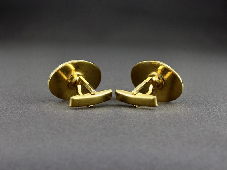 This is a back view of a pair of vintage cufflinks that have a bullet toggle style closure.