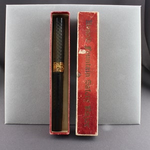 May include: A black fountain pen with gold accents in a red box. The box has the text "Always Fountain Safe & Easy" printed on it.