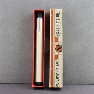 May include: A vintage razor in a red and white box. The box reads "The Elgin Razor by Elgin American".