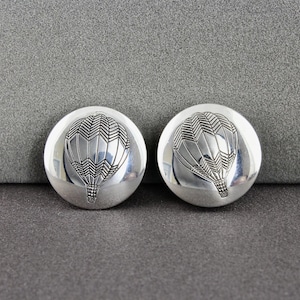 May include: A pair of silver earrings with a hot air balloon design. The balloons are detailed with a geometric pattern.