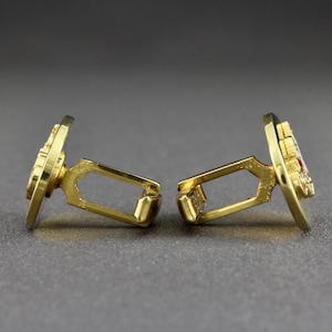 This is a side view of a pair of vintage cufflinks.