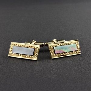 May include: A pair of gold cufflinks with a rectangular iridescent mother-of-pearl inlay.