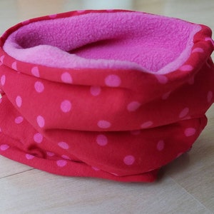 Könnte beinhalten: Roter und rosa gepunkteter Halsschmeichler mit rosa Fleece-Futter.