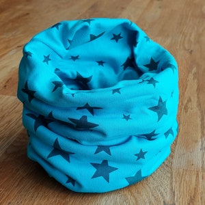 Könnte beinhalten: Ein blauer Stoff-Halswärmer mit einem schwarzen Sternenmuster.