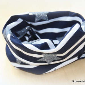 Könnte beinhalten: Ein marineblauer und weiß gestreifter Halsschmeichler mit silbernen Glitzersternen.