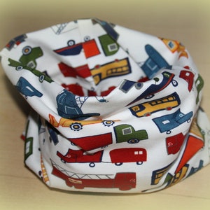 Könnte beinhalten: Weißer Stoff-Halswärmer mit einem bunten Muster aus verschiedenen Fahrzeugen, darunter LKW, Autos und Busse.