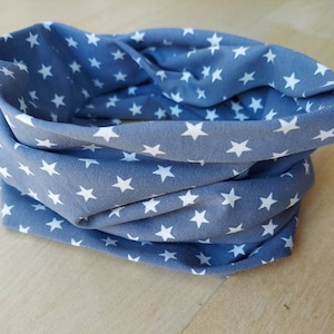 Könnte beinhalten: Ein blauer Stoff-Halswärmer mit einem weißen Sternenmuster.