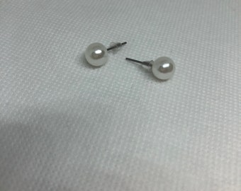 Op de afbeelding: Een paar parel oorbelletjes met zilveren steeltjes.