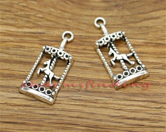 May include: Two silver charm pendants in the shape of a carousel with a horse on it. The charms are detailed and have a vintage look.