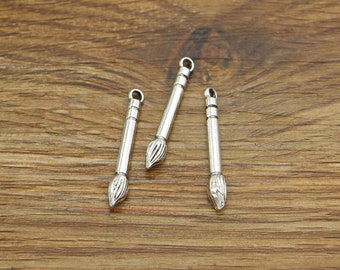 Puede incluir: Tres abalorios de pincel de plata con un bucle en la parte superior para sujetarlos a joyas u otras manualidades.