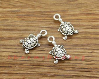 May include: Three silver turtle charms with a detailed design. The charms are perfect for jewelry making or adding a touch of whimsy to crafts.