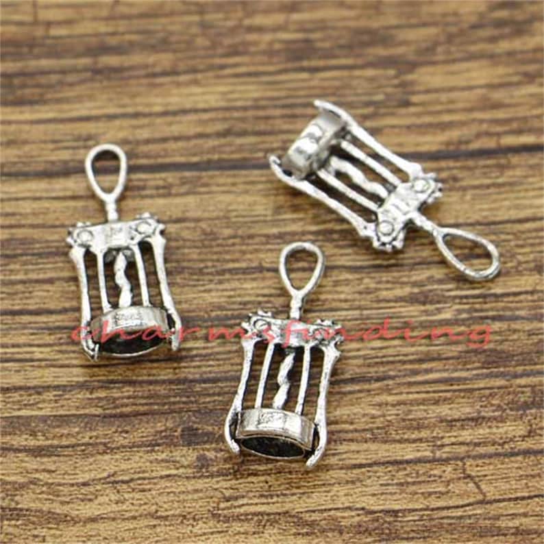 May include: Three silver-toned metal corkscrew charms. The charms are detailed with a corkscrew design and have a loop at the top for attaching to a necklace or bracelet.