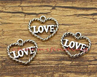 May include: Three silver-toned heart-shaped charms with the word "LOVE" inscribed inside each heart.