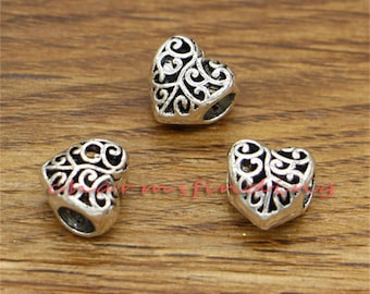 May include: Three silver heart-shaped charms with intricate filigree designs. The charms have a hole at the top for attaching to a bracelet or necklace.