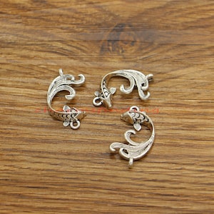 May include: Three silver-toned metal charms shaped like koi fish with intricate details. The charms have a loop at the top for attaching to jewelry or other crafts.
