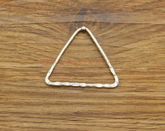 May include: Silver triangle shaped pendant with a hammered texture. The pendant is open on one side and has a small loop at the top for attaching a chain or cord.