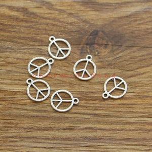 May include: Six silver peace sign charms with a loop for attaching to jewellery or other crafts.