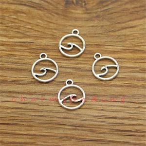 May include: Four silver-toned metal charms in the shape of a circle with a wave design inside. The charms are perfect for jewelry making or adding a nautical touch to crafts.