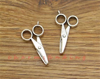 May include: Two silver-toned metal scissor charms with a loop at the top for attaching to jewellery or crafts.