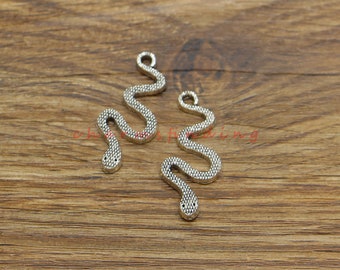 May include: Two silver snake charms with a textured surface. The charms have a loop at the top for attaching to jewelry.