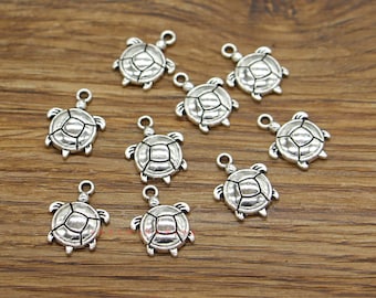 May include: Ten silver turtle charms with a loop for attaching to jewelry or other crafts.