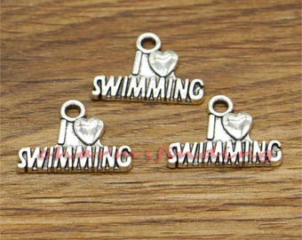 May include: Three silver charm pendants with the words "I love swimming" and a heart design.