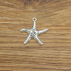 May include: Silver-toned starfish charm with a textured surface. The charm has a loop at the top for attaching to jewelry or other crafts.
