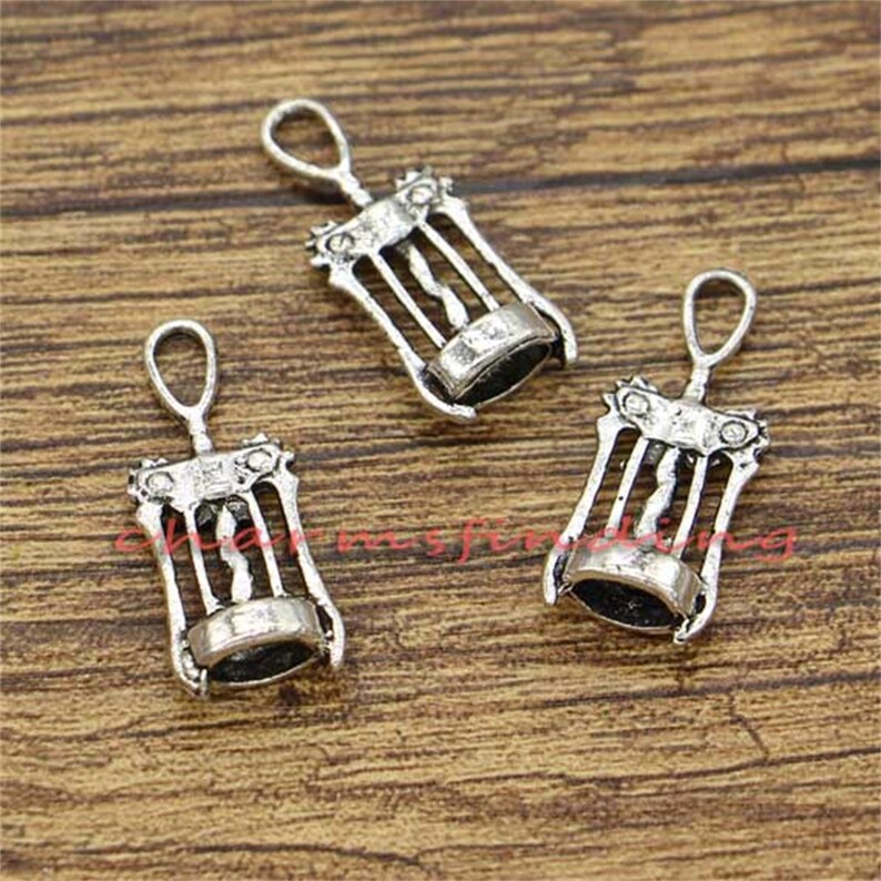 May include: Three silver-toned metal corkscrew charms. Each charm features a detailed design of a corkscrew with a loop at the top for attaching to a necklace or bracelet.
