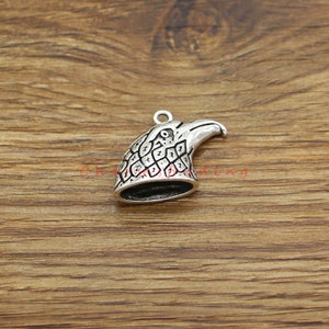 Peut inclure: Breloque en argent en forme de tête d'aigle avec gravure détaillée. Le charme est en forme de tête d'aigle avec un bec et des plumes.