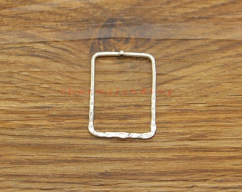 May include: A silver rectangle earring with a hammered texture.