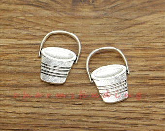 May include: Two silver-toned metal bucket charms with a simple design. The charms are perfect for adding a touch of whimsy to jewelry or crafts.