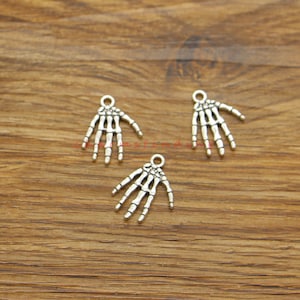 Può includere: Tre ciondoli a forma di mano scheletrica in argento con un anello nella parte superiore per attaccarli a gioielli o altri oggetti artigianali.