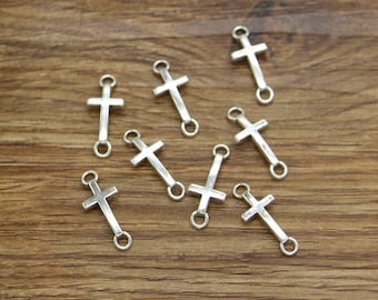 May include: Ten silver-toned cross charms with jump rings. The charms are perfect for jewelry making or adding a religious touch to crafts.