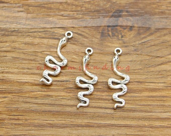 May include: Three silver snake charms with a loop at the top for attaching to jewelry. The charms are in the shape of a coiled snake with a raised head.